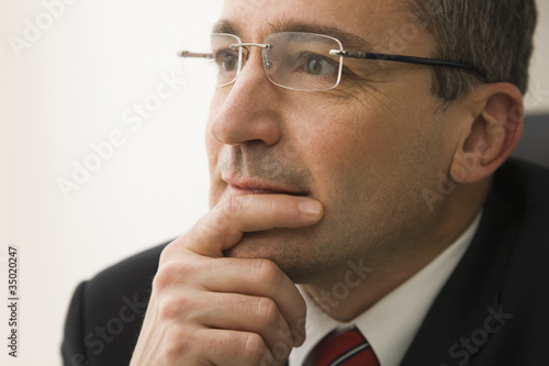 Photo: Serious Caucasian businessman with hand on chin Serious Caucasian businessman with hand on chin