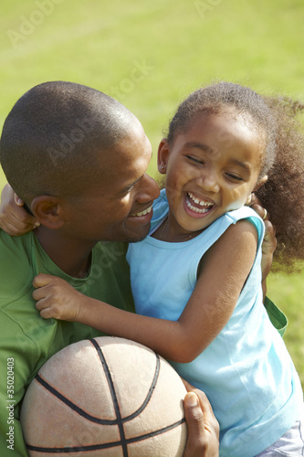 Photo: African American father hugging daughter African American father hugging daughter