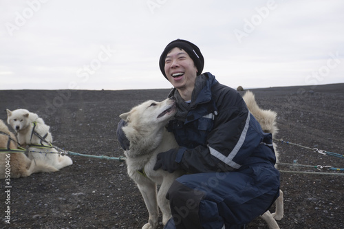 Foto: Chinese man petting dog in dog sled pack Chinese man petting dog in dog sled pack