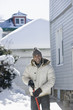 Mixed race man shoveling snow off driveway