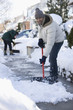 Mixed race man shoveling snow from sidewalk