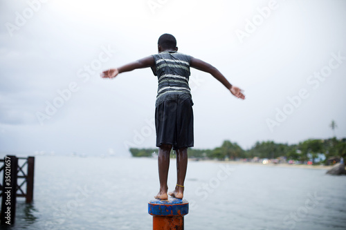 Photo: Boy on pipe about to jump in the water Boy on pipe about to jump in the water