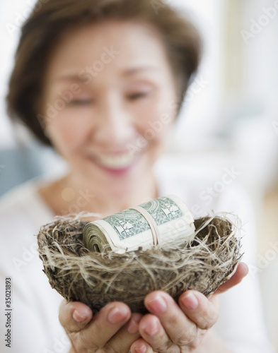 Photo: Japanese woman holding nest filled with money Japanese woman holding nest filled with money
