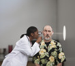 Doctor shining light through head of patient