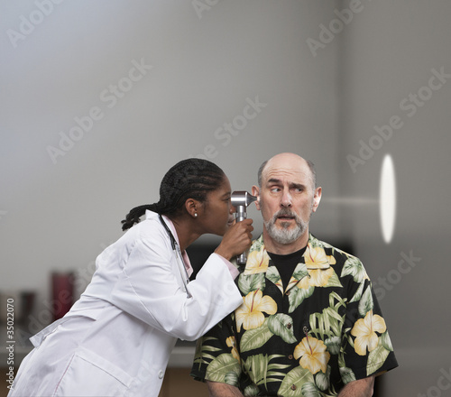 Photo: Doctor shining light through head of patient Doctor shining light through head of patient
