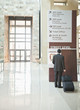 Traveling Hispanic businessman looking at building directory