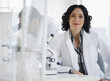 Hispanic researcher in laboratory next to microscope
