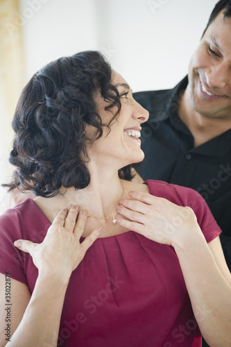 Photo: Smiling man giving wife elegant necklace Smiling man giving wife elegant necklace