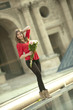 Caucasian woman standing near fountain with bouquet at the Louvre