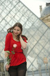 Caucasian woman standing  at the Louvre with rose