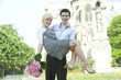Caucasian man carrying girlfriend near Notre Dame