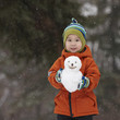Chinese boy holding small snowman