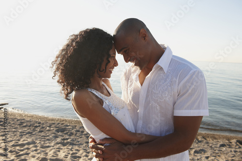 Photo: Couple hugging on beach near ocean Couple hugging on beach near ocean