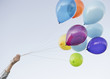 Caucasian woman holding bunch of balloons