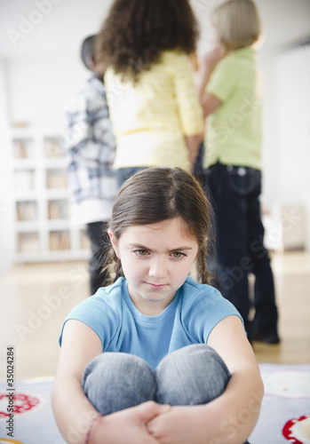 Photo: Lonely girl ignoring friends playing Lonely girl ignoring friends playing