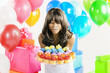 African American woman with birthday presents and cupcakes