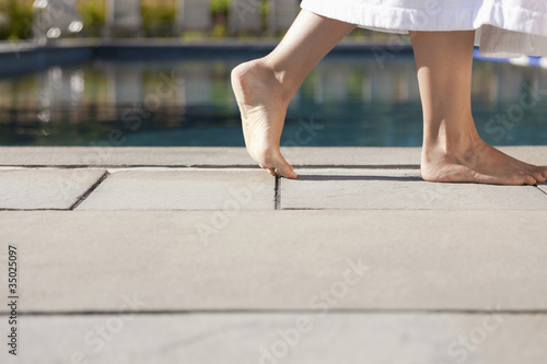 Photo: Woman walking near swimming pool Woman walking near swimming pool