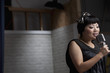 Asian woman singing into microphone