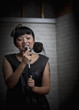 Asian woman singing into microphone