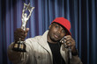 Black man holding trophy speaking at microphone
