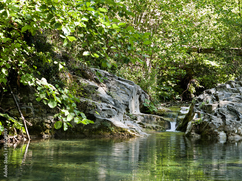 Photo: Beautiful woodland stream with waterfall, early morning sunlight Beautiful woodland stream with waterfall, early morning sunlight