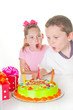 Boy blowing out girl's birthday candles