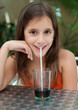 Latin girl drinking a coke in an outdoors cafe