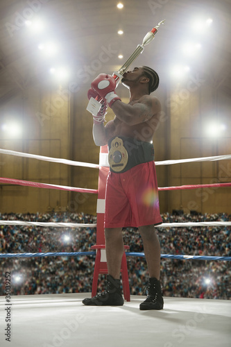 Photo: African American kissing trophy in boxing ring African American kissing trophy in boxing ring