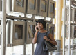 Photo: Black businesswoman talking on cell phone next to arrival departure board in airport Black businesswoman talking on cell phone next to arrival departure board in airport
