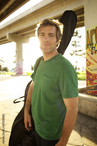Photo: Smiling Caucasian man carrying double bass Smiling Caucasian man carrying double bass