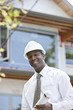 Black architect holding blueprints on construction site