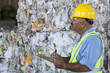 Hispanic sanitation worker with clipboard in recycling plant