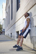 African American man leaning against wall after exercise