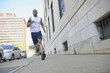 African American man running on city sidewalk