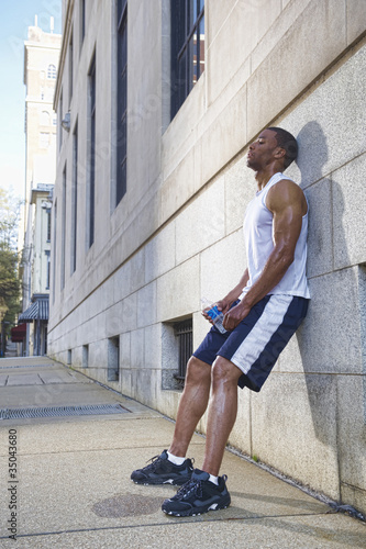 Photo: African American man leaning against wall after exercise African American man leaning against wall after exercise