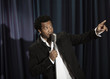 Black singer in tuxedo holding microphone