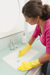 Hispanic woman cleaning bathroom sink