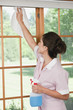 Hispanic maid cleaning windows