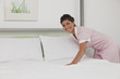 Hispanic maid making bed