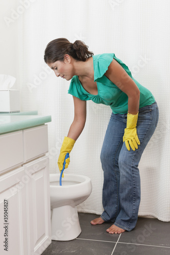 Photo: Hispanic woman scrubbing toilet in bathroom Hispanic woman scrubbing toilet in bathroom
