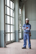 Hispanic worker in hard-hat standing indoors