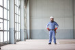 Hispanic worker in hard-hat standing indoors