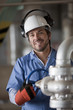 Hispanic worker turning valve on pipe