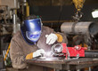 Mixed race machinist working at arc welding