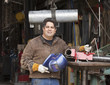 Mixed race machinist holding helmet