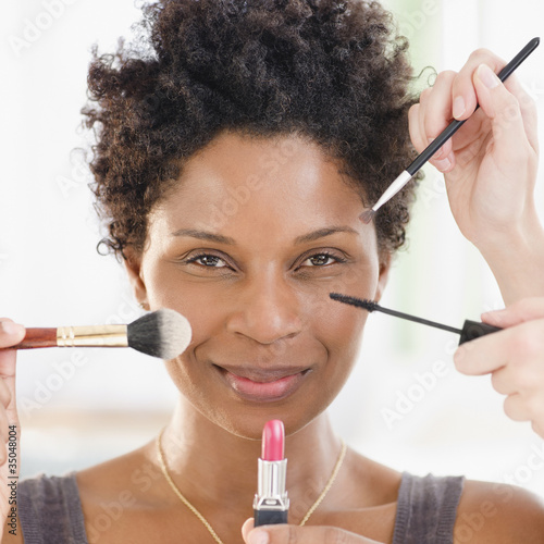 Photo: People putting makeup on Black woman People putting makeup on Black woman
