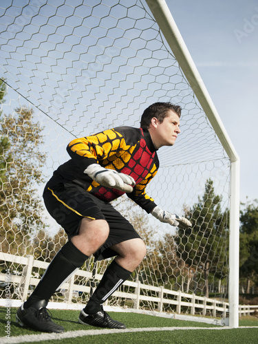Photo: Mixed race goalkeeper protecting goal Mixed race goalkeeper protecting goal