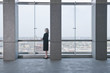 Caucasian businesswoman looking out lobby window