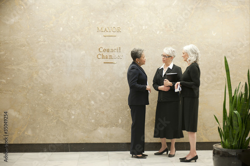Foto: Businesswomen talking together in office corridor Businesswomen talking together in office corridor