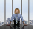 Businessman with lion's head leaning on table